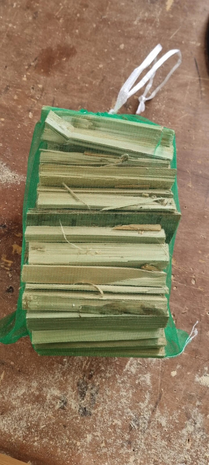 Stack of green paper or cards in a green bag on a brown surface