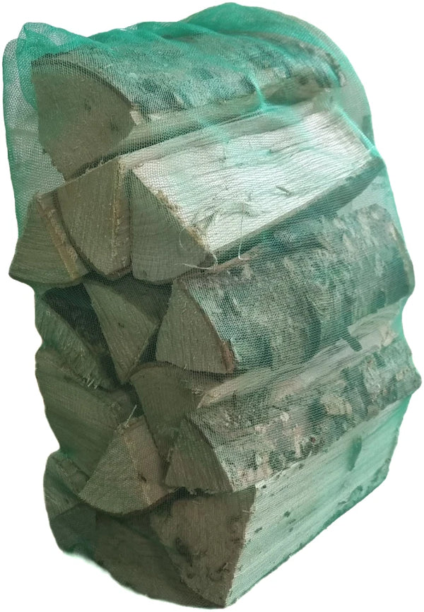Stack of chopped wood with a green mesh bag on a white background