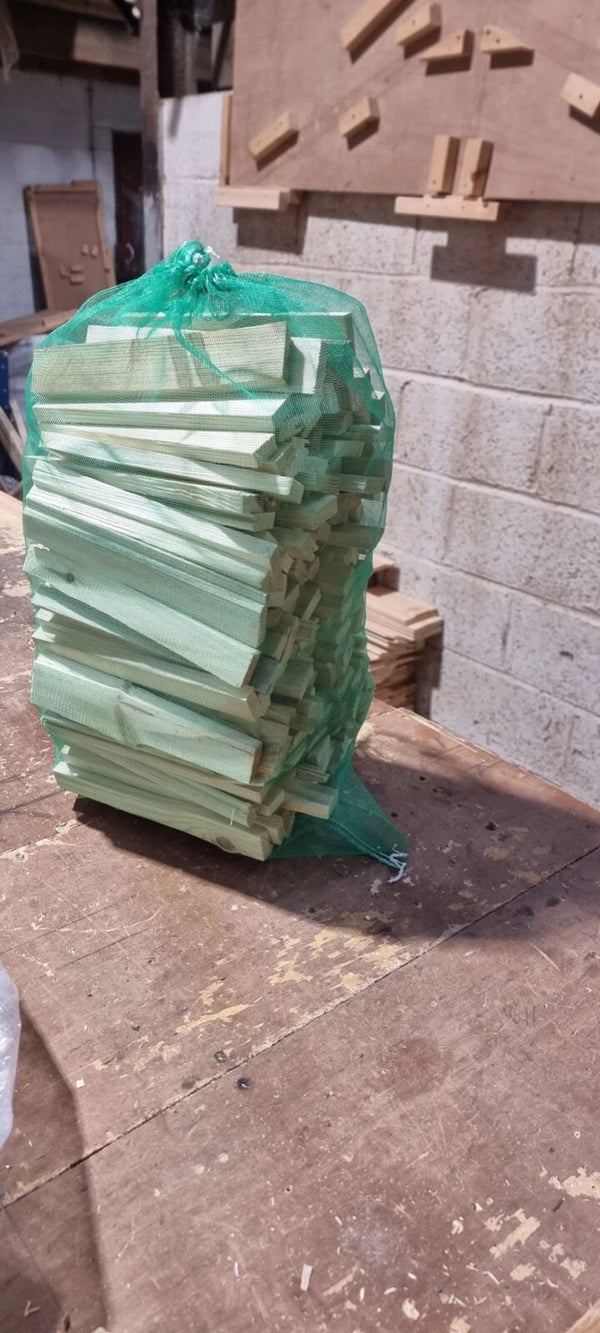 Stack of green boards in a green bag against a brick wall.